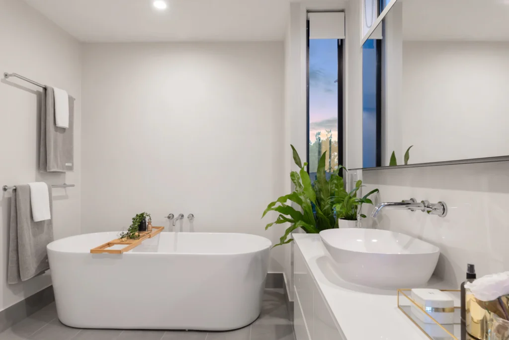 Lichte badkamer met vrijstaand bad en houten wastafelmeubel